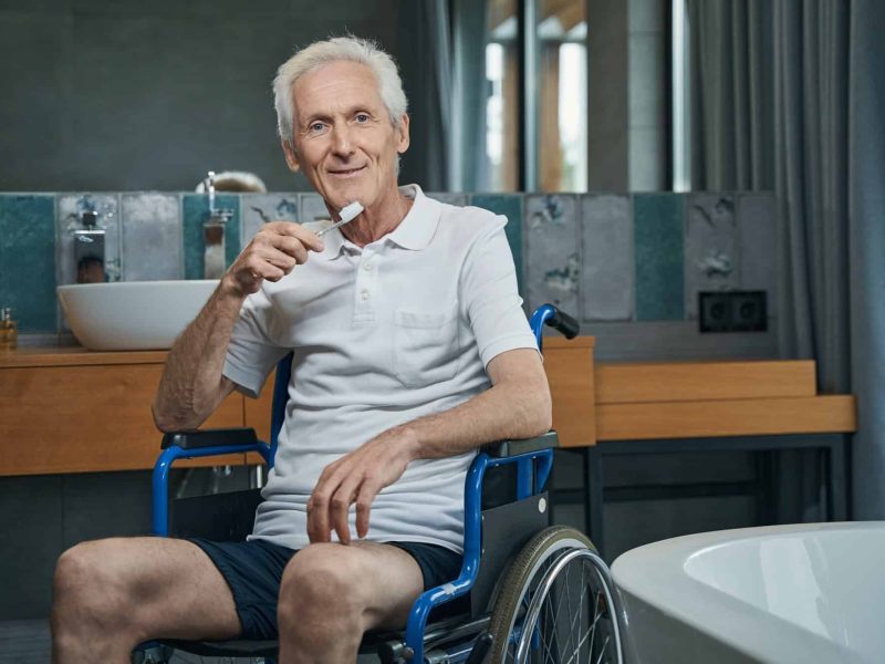 Pleased male person with disability holding toothbrush